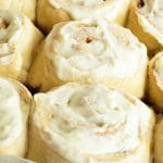 A tray of baked gluten free cinnamon rolls with icing.