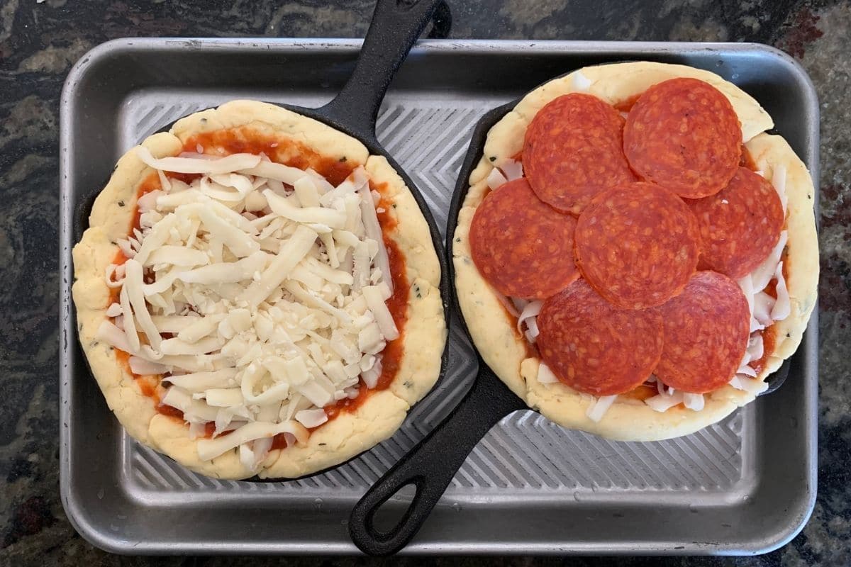 mini deep dish pizzas in small cast iron skillets. They are ready to bake.
