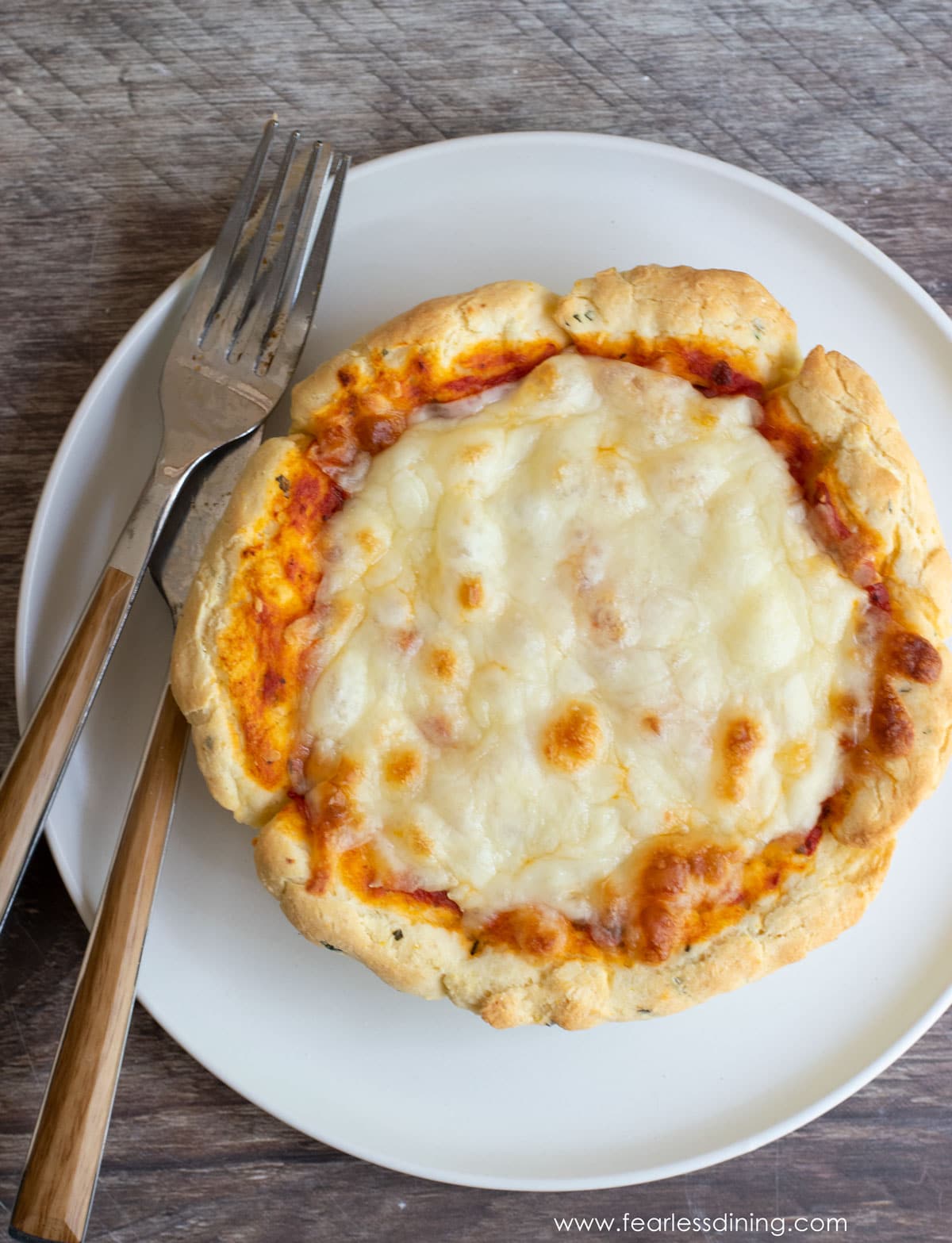 The top view of a small deep dish cheese pizza.