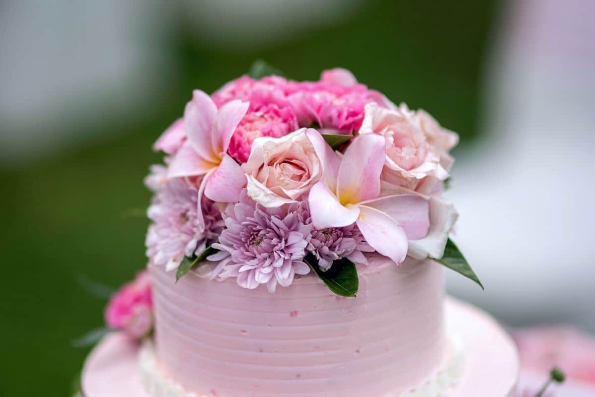 Flowers on the top of a wedding cake.