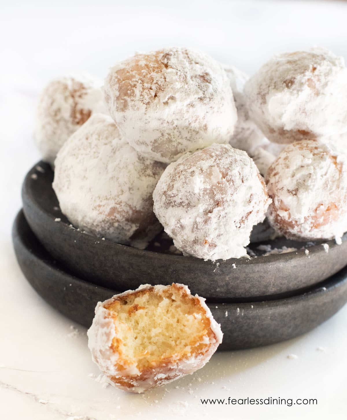 A close up of a donut hole with a bite taken out.