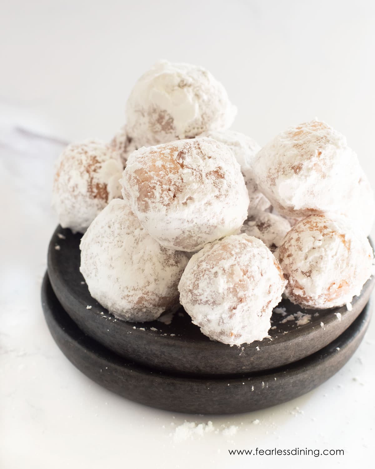 A bowl of powdered sugar donut holes.