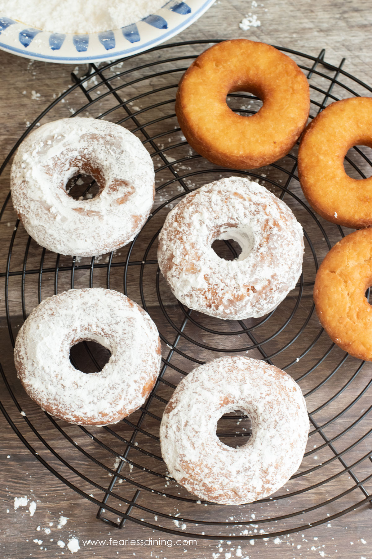 Dipping donuts in powdered sugar.