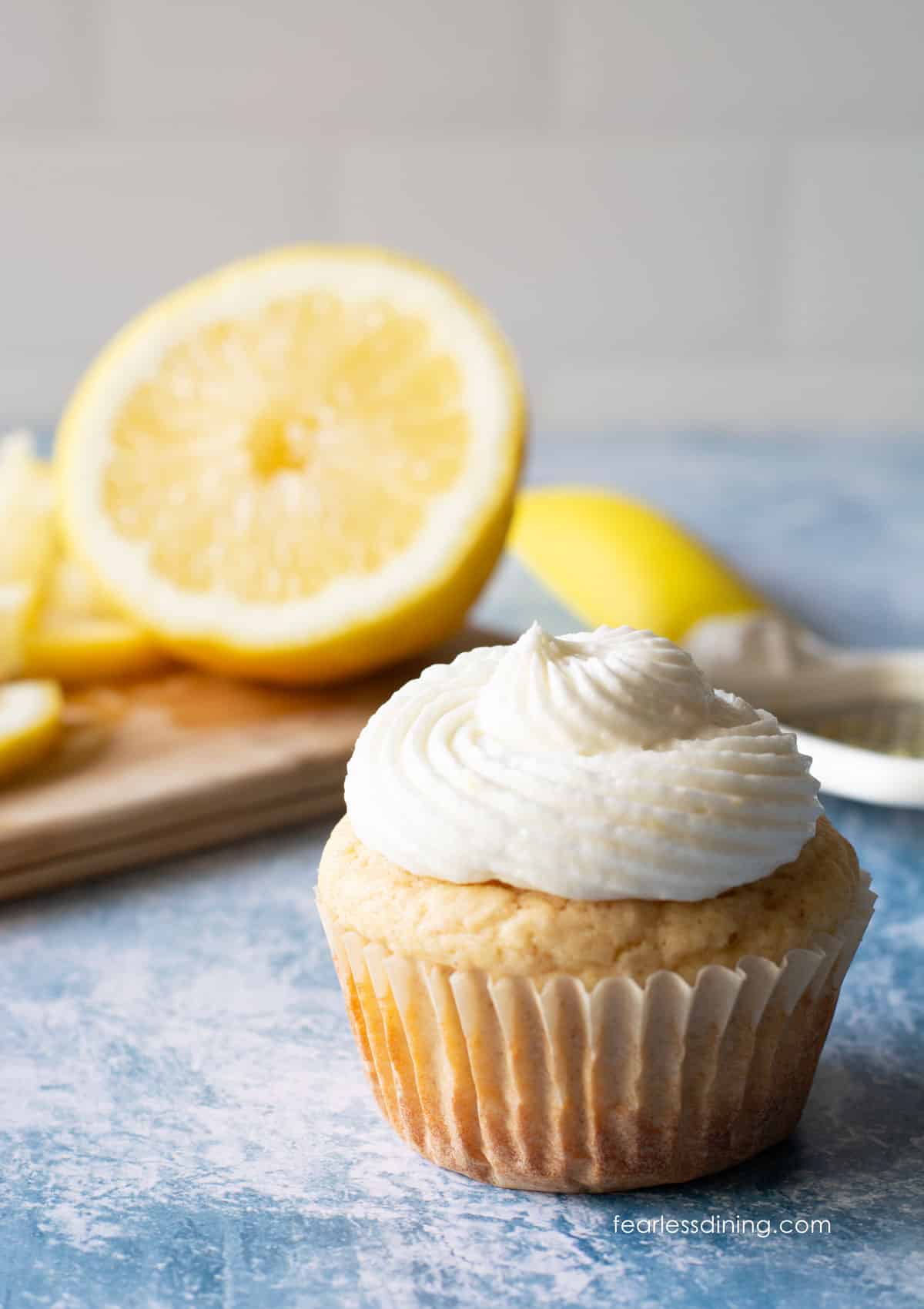 A frosted gluten-free lemon cupcake on the counter.