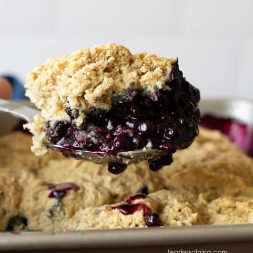 A serving scoop full of gluten-free blueberry cobbler.