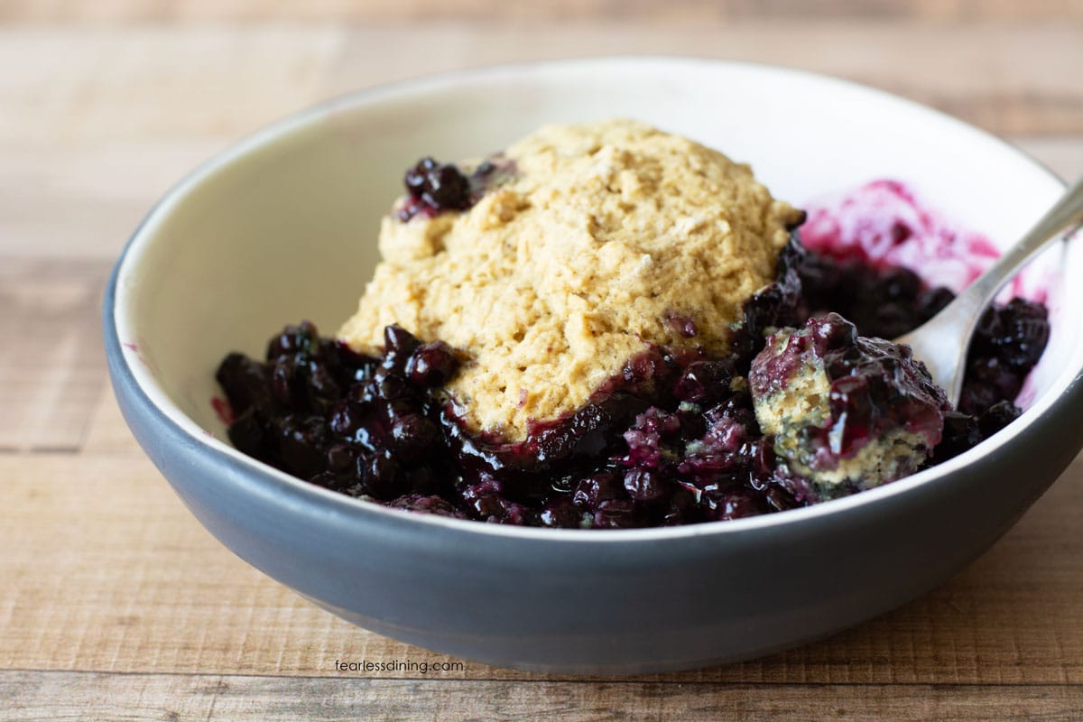 A close up of the gluten-free blueberry cobbler made with frozen blueberries in a bowl.