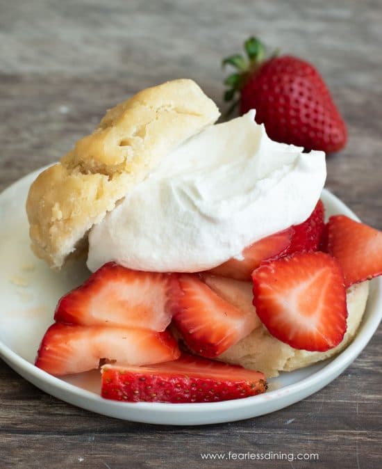 A strawberry loaded shortcake. It is topped with whipped cream.