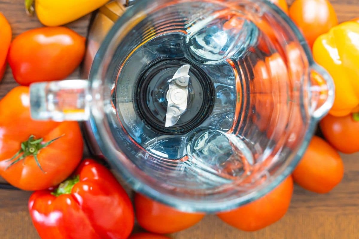 Heirloom tomatoes next to a blender.