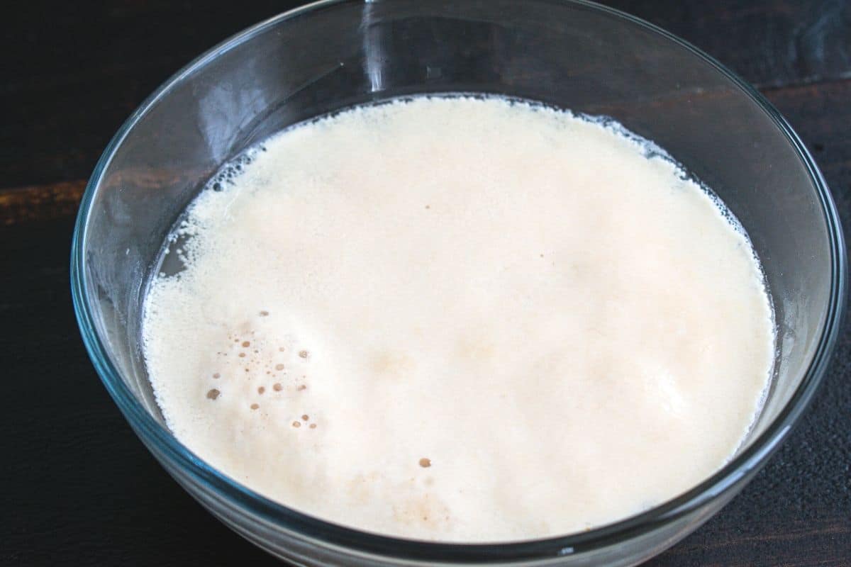 A small glass bowl with foaming yeast.