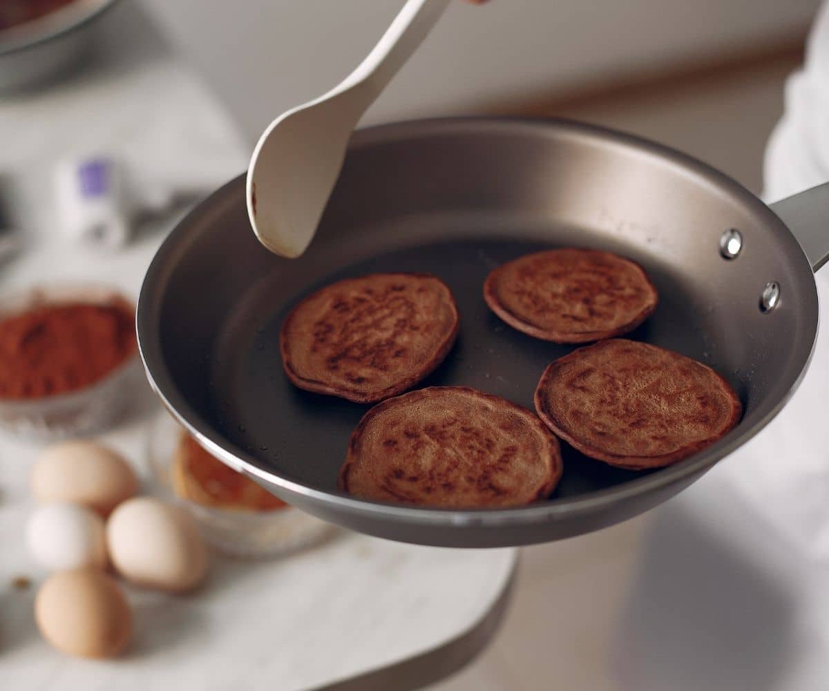 Four buckwheat pancakes in a frying pan.