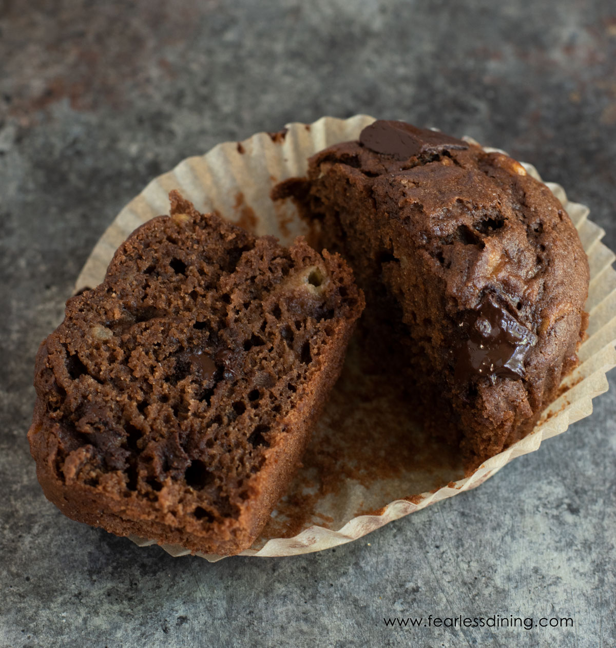 A gluten free chocolate banana muffin sliced in half.