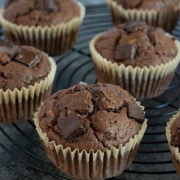 A black wire rack filled with gluten free chocolate banana muffins.