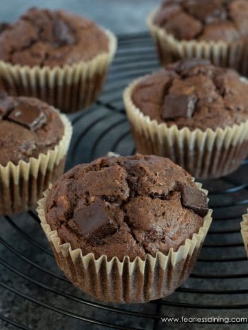 a black wire rack filled with gluten free chocolate banana muffins.