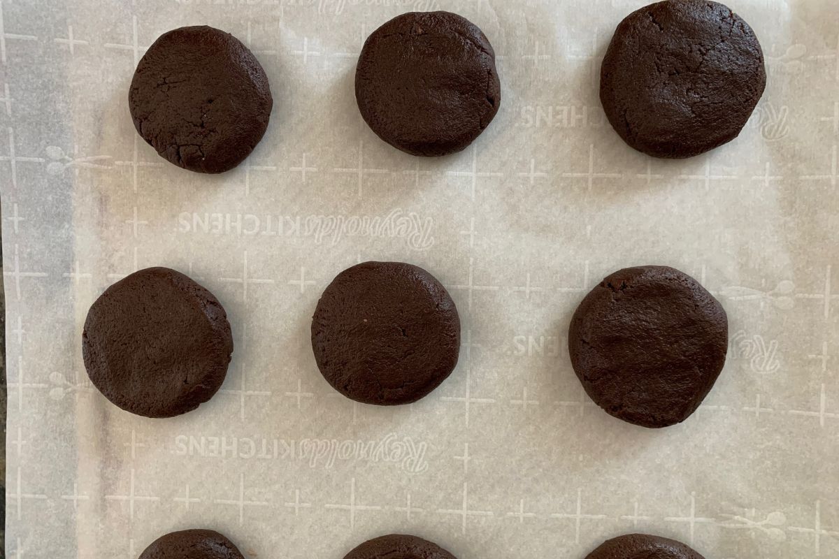 chocolate cookie balls on a piece of parchment paper.