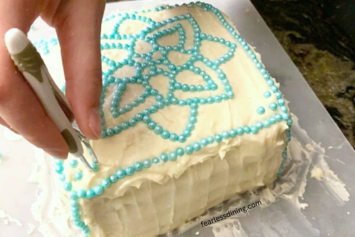A photo showing how to decorate the cake with sprinkles.