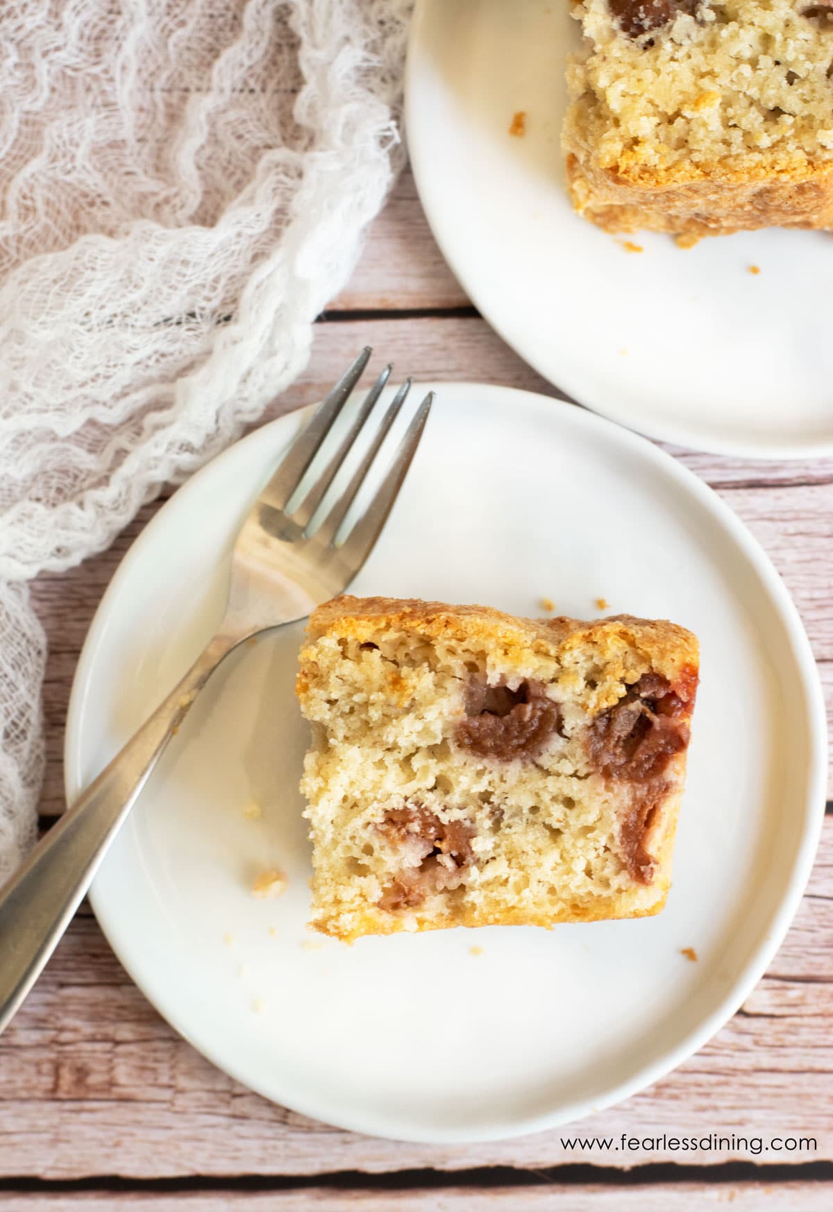 Two slices of cherry cake on plates.