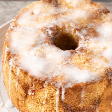 Monkey bread on a white plate. It is topped with glaze.