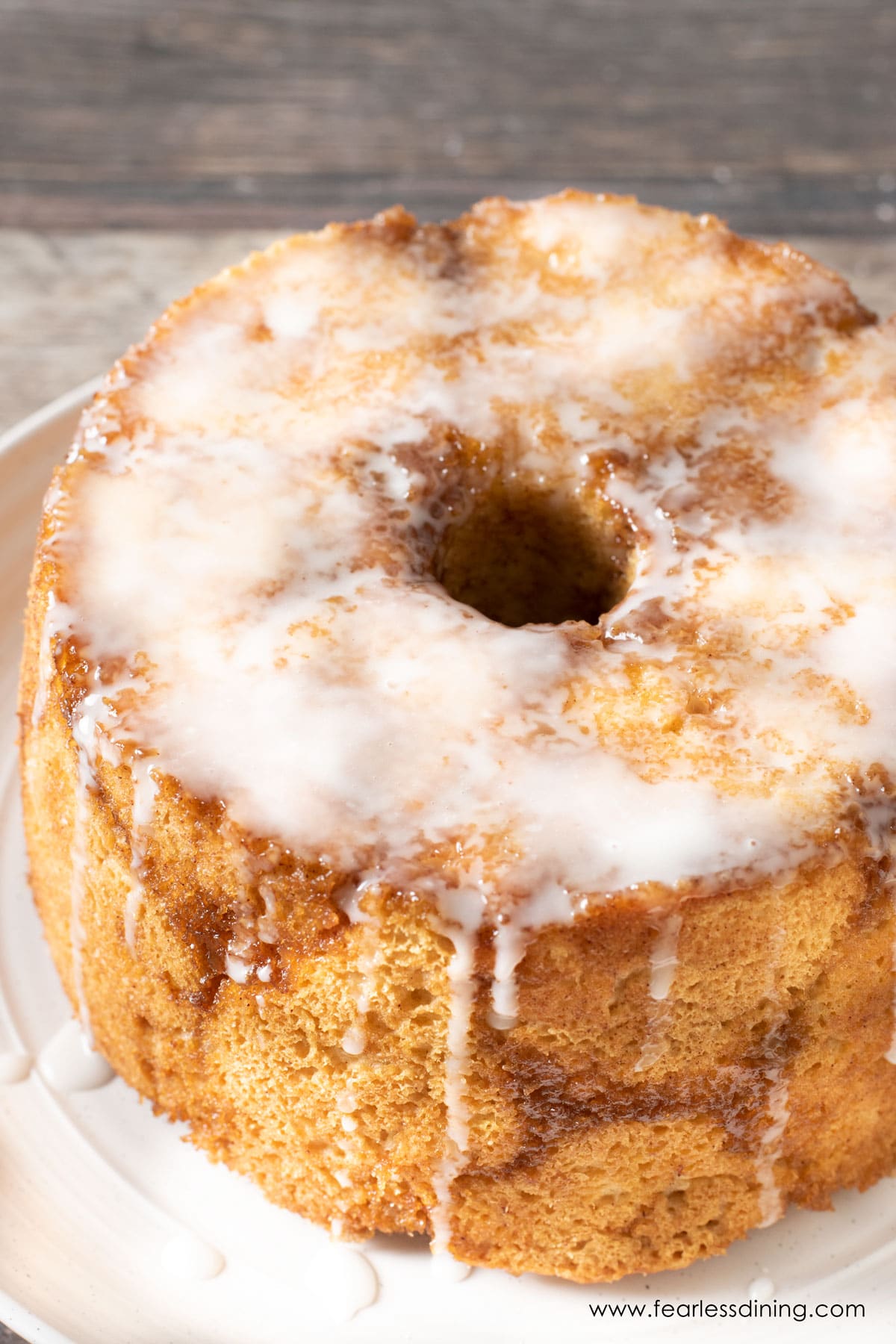 The gluten-free monkey bread on a white plate. It is topped with glaze.