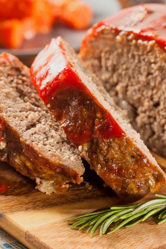 Sliced meatloaf on a wooden cutting board.