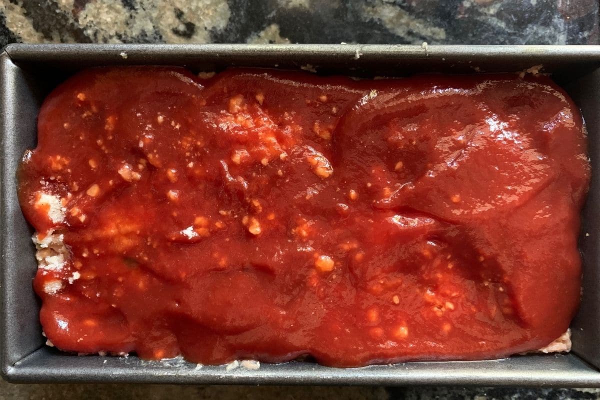 A meatloaf in a loaf pan ready to bake.