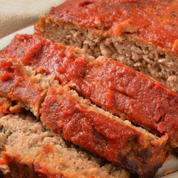 Sliced meatloaf on a serving plate.