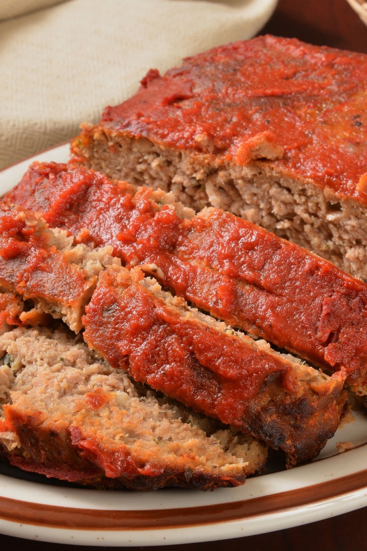 Sliced meatloaf on a serving plate.