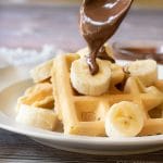 Drizzling Nutella over the mochi waffles.