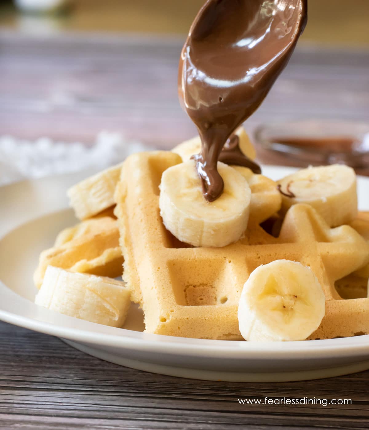 Drizzling Nutella over the mochi waffles.