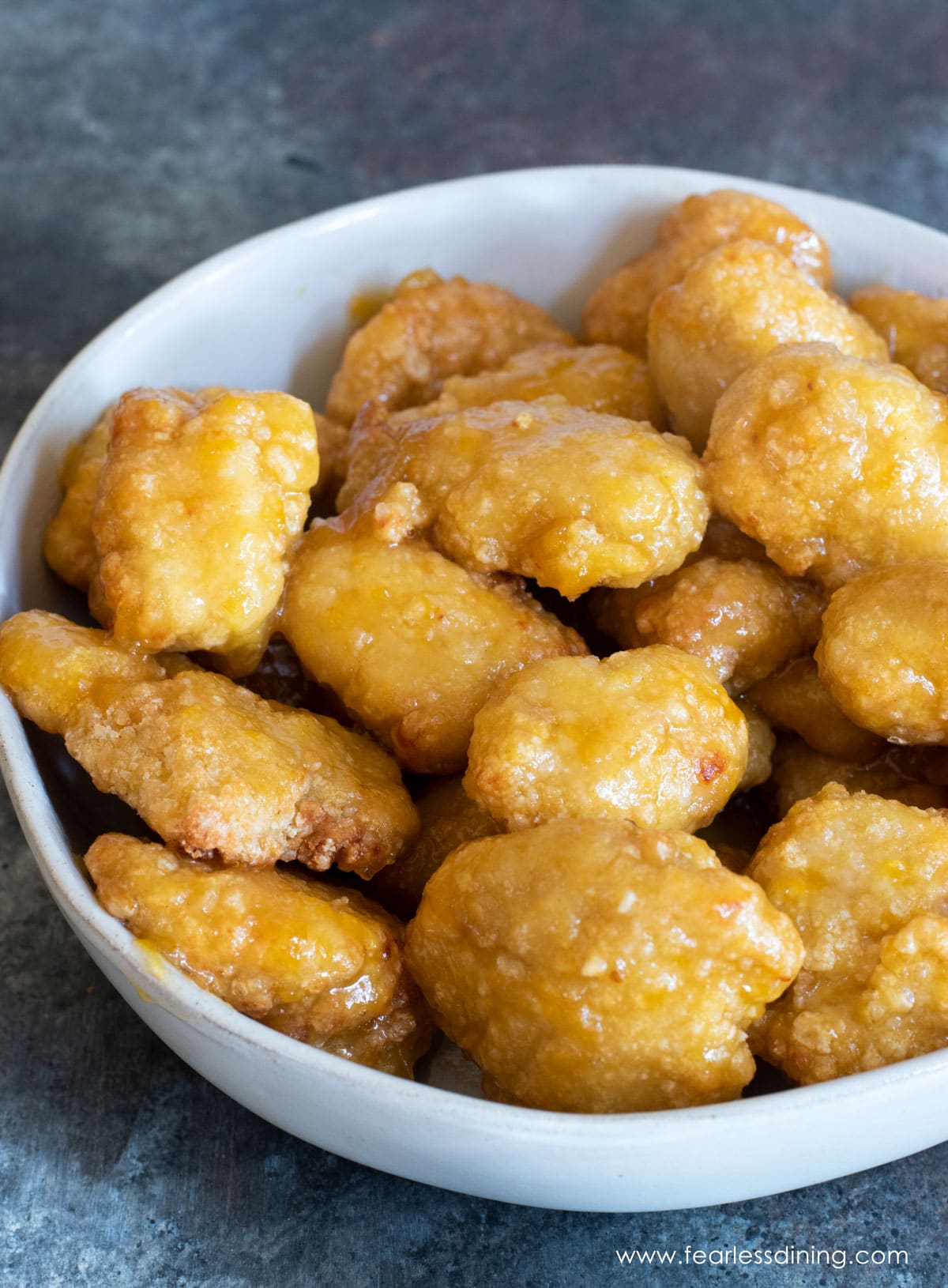 A bowl of gluten free orange chicken.