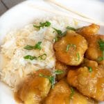 A plate with orange chicken over rice.