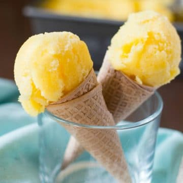 two pineapple sorbet cones standing in a glass.
