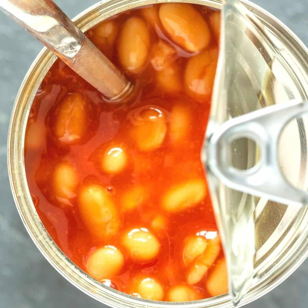 A close up of an open can of baked beans.