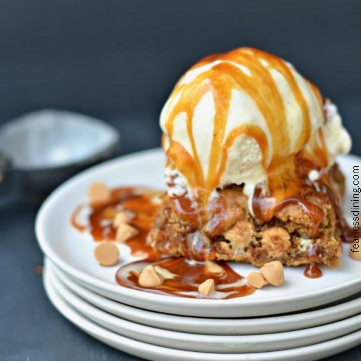 A blondie sundae with ice cream and caramel sauce.