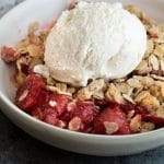 A Pinterest image of a bowl of gluten free strawberry rhubarb crisp.