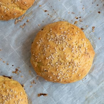 Gluten free hamburger buns on a baking sheet.