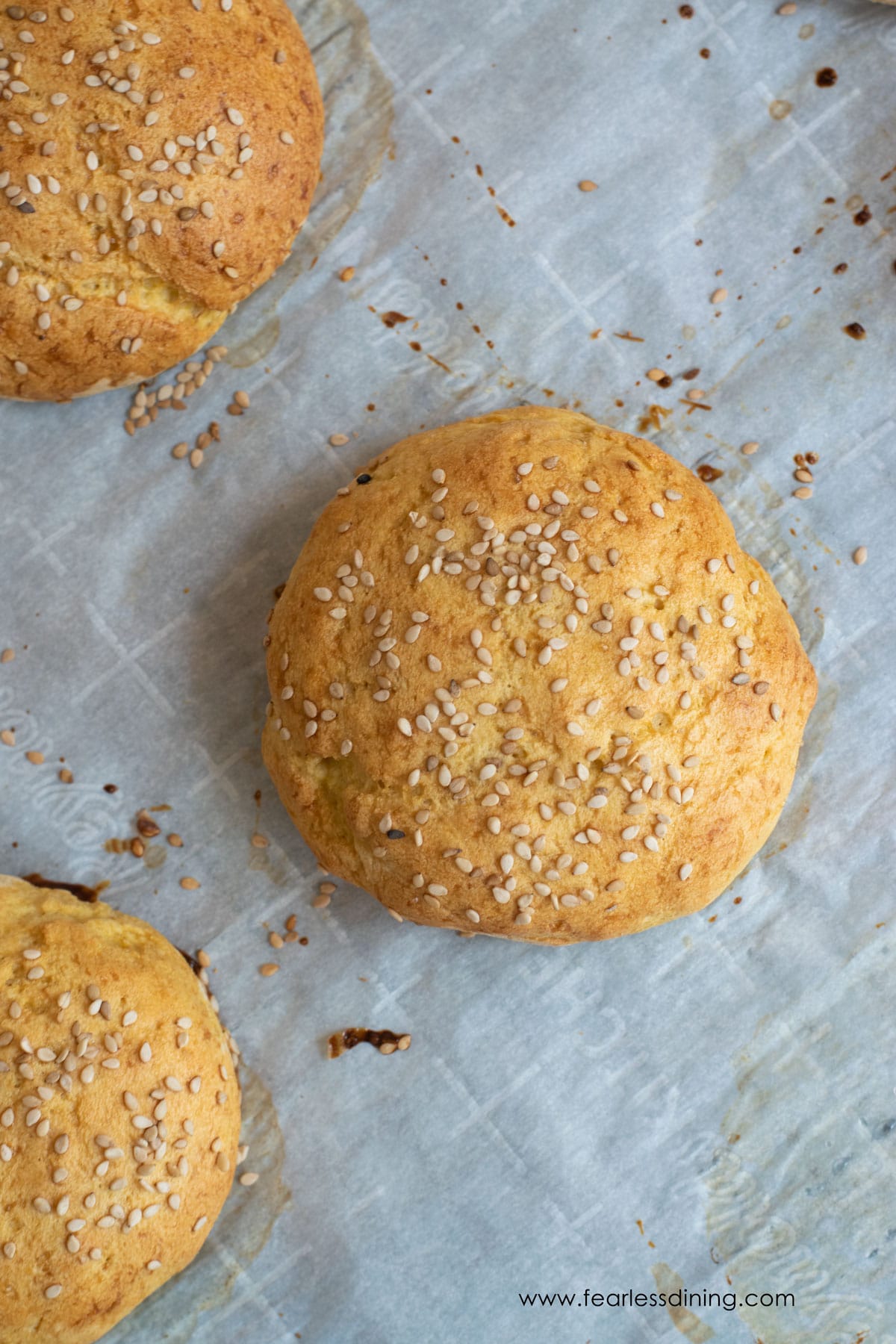 Gluten free hamburger buns on a baking sheet.