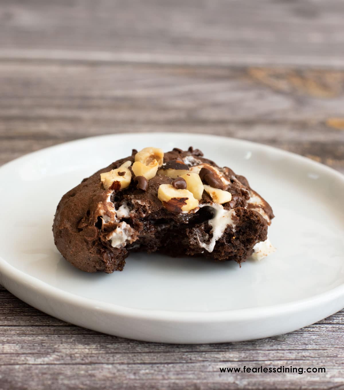 A big rocky road cookie with a bite taken out.