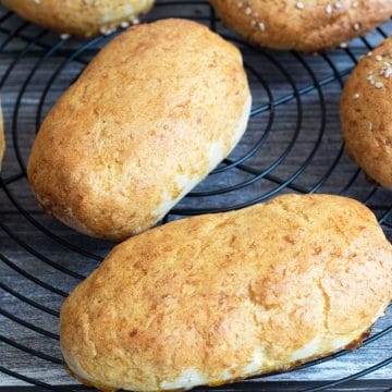 Baked hot dog buns cooling on a rack.