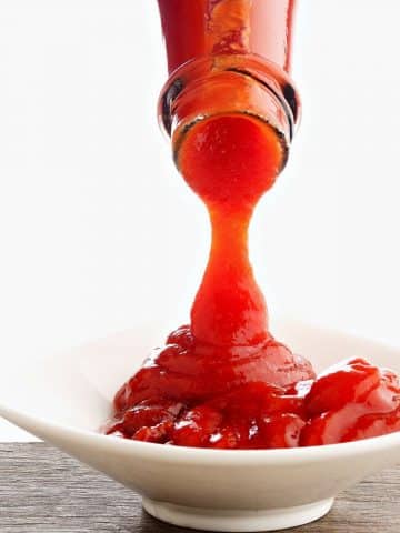 Pouring ketchup into a dish.