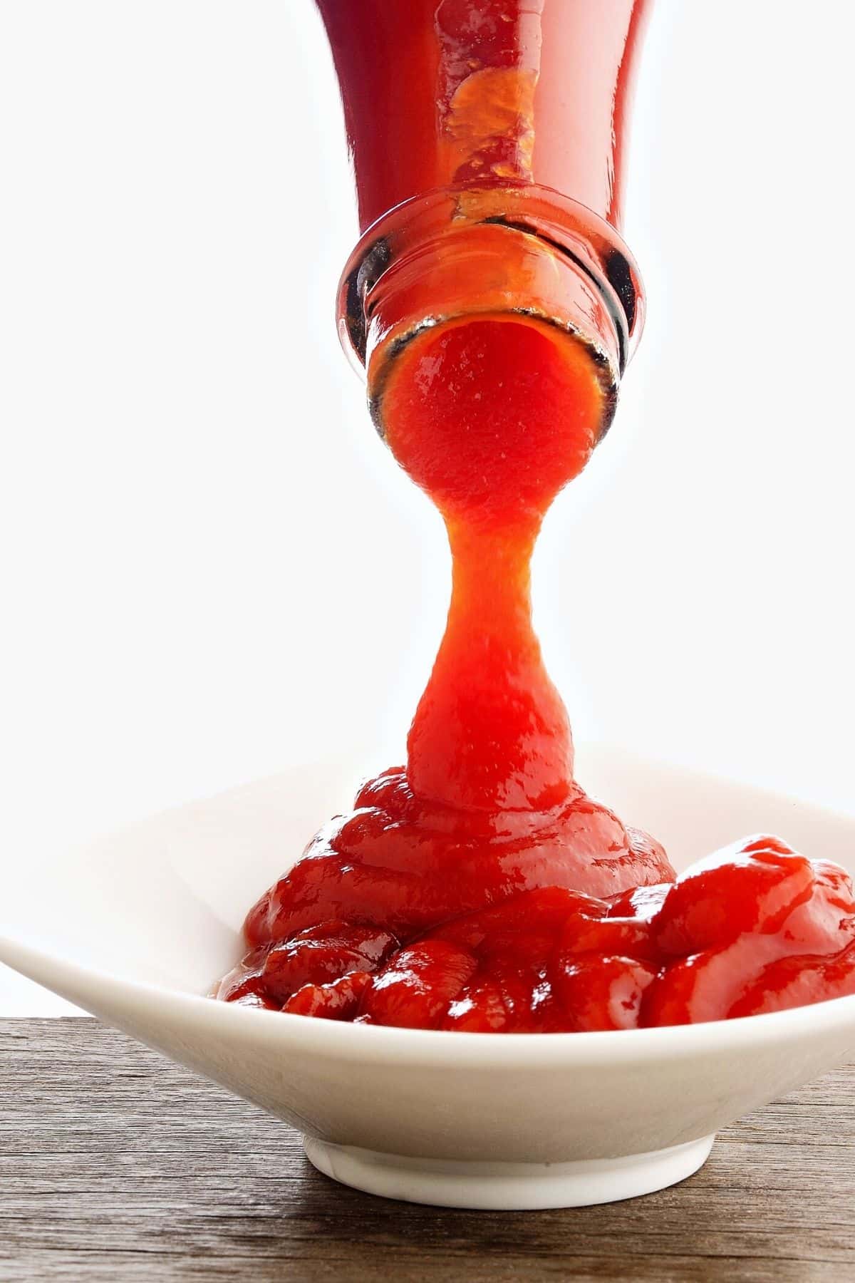 Pouring ketchup into a dish.