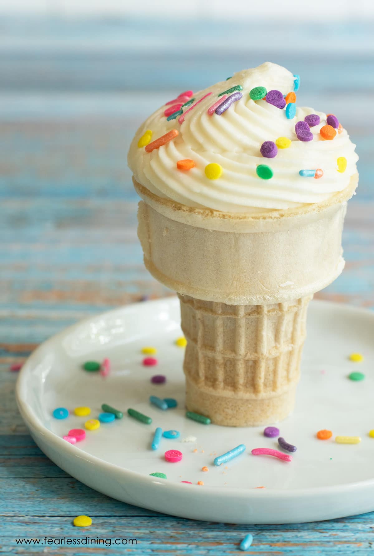 A gluten free cupcake cooked in a mug on a plate.