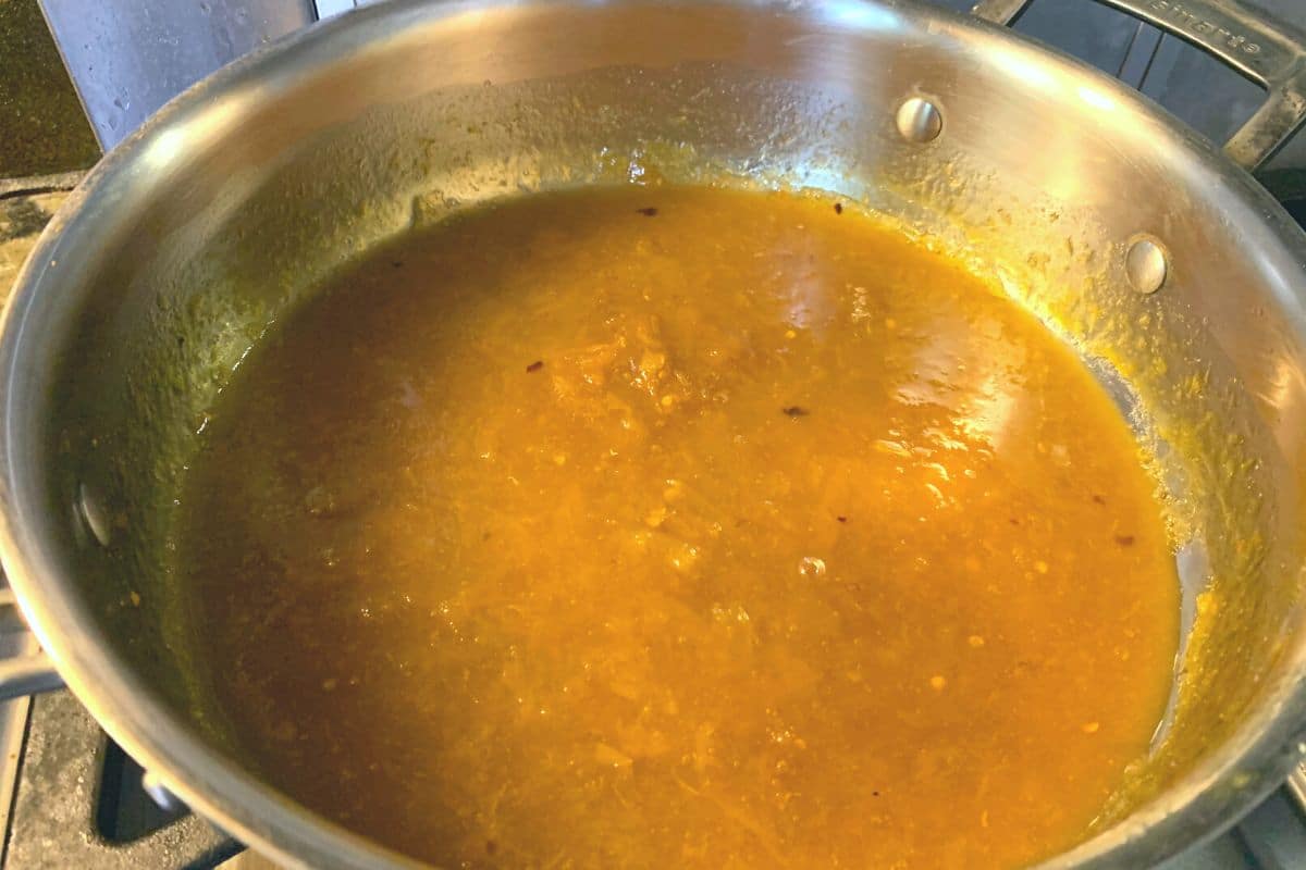 Orange sauce simmering on the stove.