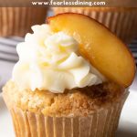 A Pinterest image of a peach cupcake on a white plate.