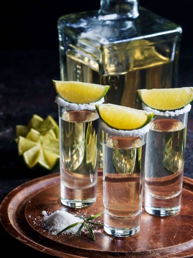 tequila shots with limes on top.
