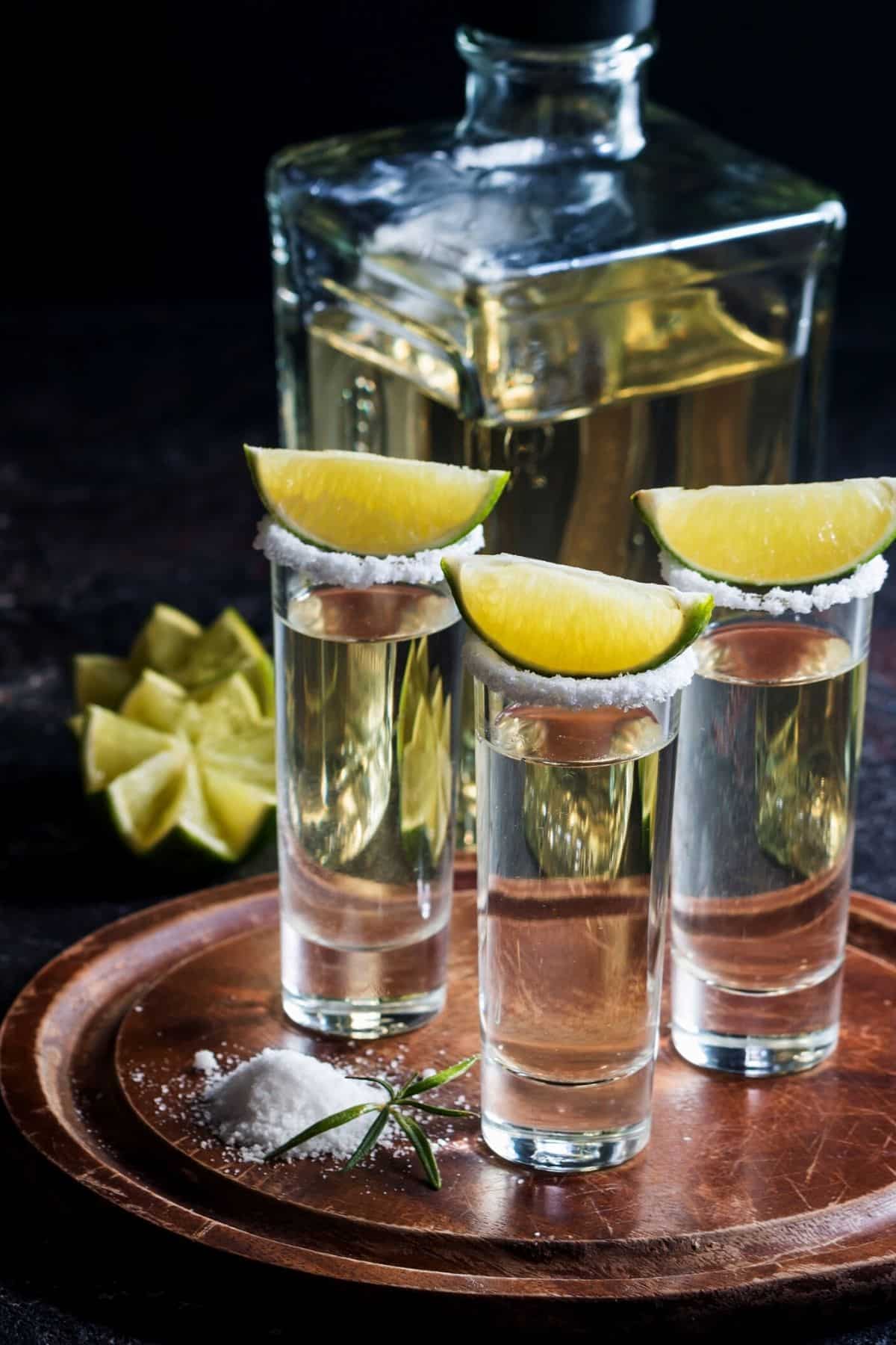 Some tequila shots with limes on top.