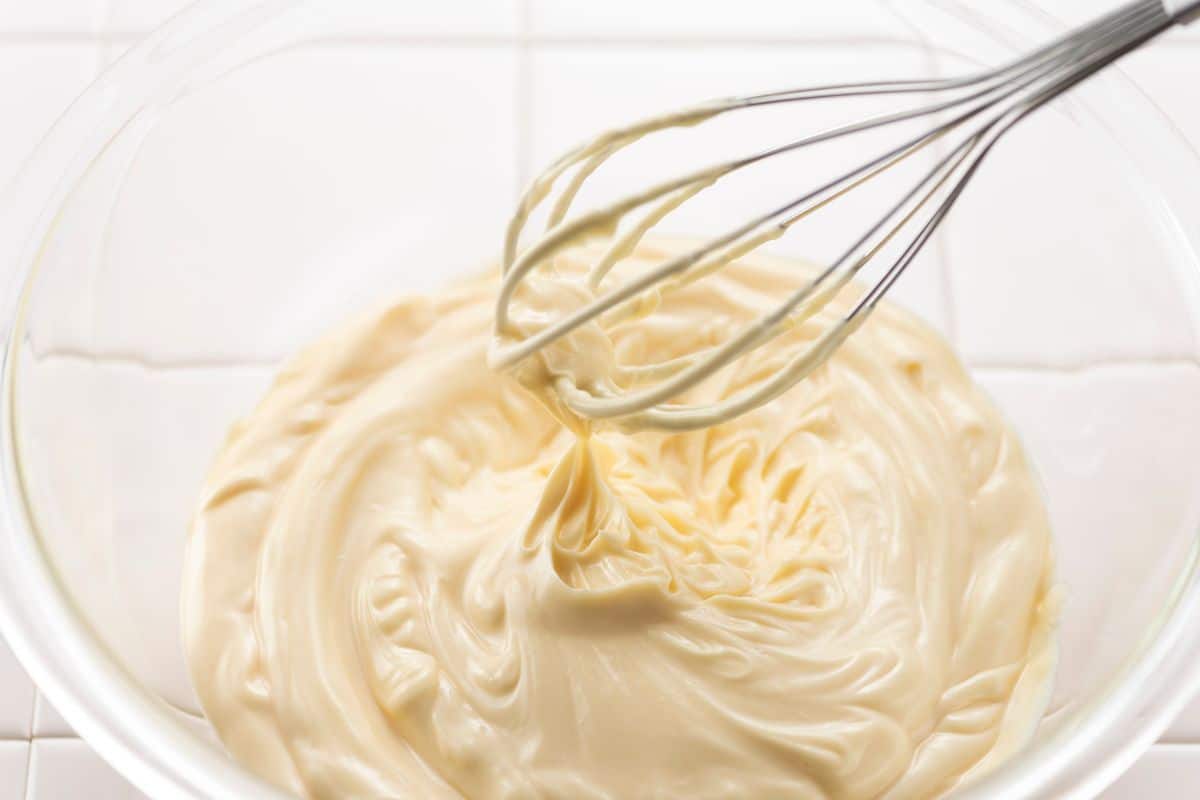 A glass bowl of whipped mayonnaise.