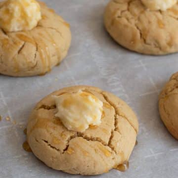 a tray of gluten free cornbread cookies topped with honey butter and honey.