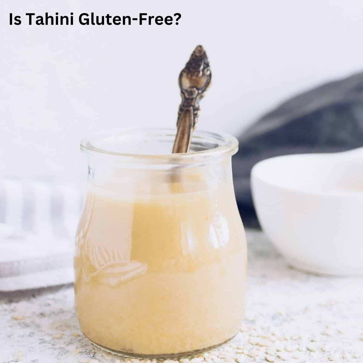 A small jar of tahini with an ornate spoon in it.