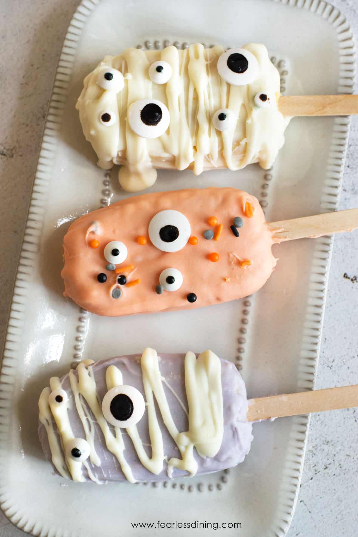 Halloween cakesicles on a plate.