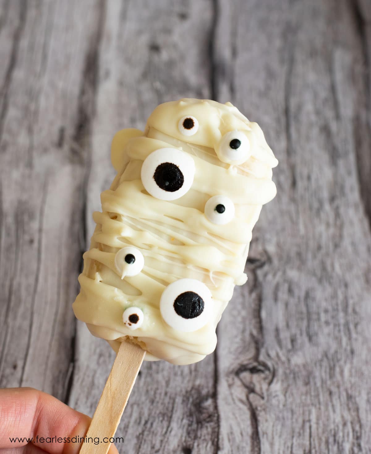 Holding up a white mummy cakesicle.